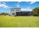 Beautiful backyard featuring a large grassy area, screened pool, and picturesque views of the lake at 308 Chantilly Trl, Bradenton, FL 34212