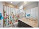 Bright bathroom featuring a shower with floral curtain and a granite topped vanity at 308 Chantilly Trl, Bradenton, FL 34212