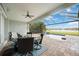 Enjoy outdoor living on this covered patio with a ceiling fan, overlooking the screened pool and lake view at 308 Chantilly Trl, Bradenton, FL 34212