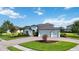 Charming light blue home featuring a three-car garage and landscaped front yard at 308 Chantilly Trl, Bradenton, FL 34212