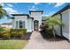 Inviting entrance to a single-story home with lovely landscaping, a brick walkway, and a charming facade at 308 Chantilly Trl, Bradenton, FL 34212