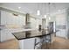 Modern kitchen with white cabinets, stainless steel appliances, backsplash and black countertop island with seating at 308 Chantilly Trl, Bradenton, FL 34212