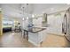Large kitchen with island, white cabinets, and stainless steel appliances, flowing into the dining and living areas at 308 Chantilly Trl, Bradenton, FL 34212