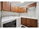 Convenient laundry room featuring modern washer and dryer, ample countertop space, and wooden cabinets at 308 Chantilly Trl, Bradenton, FL 34212