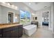 This is a full bathroom with dual sinks, a free-standing tub, and a large window view at 308 Chantilly Trl, Bradenton, FL 34212