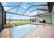 Relaxing screened pool with waterfall, surrounded by brick pavers and lush landscaping, offering privacy and beauty at 308 Chantilly Trl, Bradenton, FL 34212
