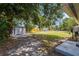 Large backyard featuring a storage shed and mature trees offering shade, providing ample space for outdoor activities at 3102 16Th W Ave, Bradenton, FL 34205