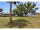 Expansive backyard featuring a lush lawn, privacy fence, and mature trees offering ample shade and a serene outdoor space at 3102 16Th W Ave, Bradenton, FL 34205