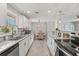 Open kitchen featuring white cabinets, granite counters, stainless steel appliances, and adjacent dining area at 3102 16Th W Ave, Bradenton, FL 34205