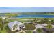 Aerial view of a golf course, lake and clubhouse surrounded by lush green landscape and palm trees at 3118 Torta Ct, Bradenton, FL 34211
