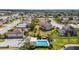 Aerial view of a community pool featuring sun shade, lounge seating, and lush landscaping and other neighborhood homes at 327 64Th Avenue E Cir, Bradenton, FL 34203