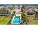 Aerial view of a community pool featuring palm trees, sun shade, lounge seating, landscaping and other neighborhood homes at 327 64Th Avenue E Cir, Bradenton, FL 34203