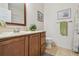 Bathroom featuring a wood vanity, sink, toilet, and decorative accents at 327 64Th Avenue E Cir, Bradenton, FL 34203
