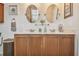 Double vanity with framed mirrors, tile countertops, and dark wood cabinets at 327 64Th Avenue E Cir, Bradenton, FL 34203