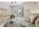 Cozy bedroom featuring large window, ceiling fan, and dresser with decorative mirror at 327 64Th Avenue E Cir, Bradenton, FL 34203