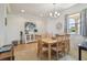 Bright dining room with a chandelier, a white door, and a large, square wooden table at 327 64Th Avenue E Cir, Bradenton, FL 34203