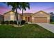 Beautiful single-story home with a well-kept lawn, palm trees, and an attached garage at 327 64Th Avenue E Cir, Bradenton, FL 34203