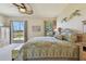 Bright main bedroom features a ceiling fan, paisley bedding, and sliding glass doors to the lanai at 327 64Th Avenue E Cir, Bradenton, FL 34203