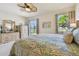 Well-lit main bedroom boasts light carpet, paisley bedding, ceiling fan, and a water view at 327 64Th Avenue E Cir, Bradenton, FL 34203