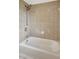 Bathtub with tile surround and shower head in a well-lit bathroom at 3510 Shawn St, Punta Gorda, FL 33980