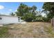 This backyard features a grassy area with a fire pit and a home with white siding at 3616 Stardust Pl, Sarasota, FL 34232