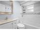Well-lit bathroom featuring a vanity, toilet, and bathtub with white tiling and chrome fixtures at 3616 Stardust Pl, Sarasota, FL 34232