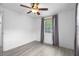 This bedroom features wood-look floors, a ceiling fan, and a window with gray curtains at 3616 Stardust Pl, Sarasota, FL 34232