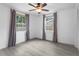 Sun-filled bedroom featuring two windows, light-colored wood-look floors, and a ceiling fan at 3616 Stardust Pl, Sarasota, FL 34232