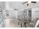 Dining area offers a glass table and cloth chairs, a tile floor, a ceiling fan, and access to other rooms at 3616 Stardust Pl, Sarasota, FL 34232