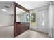 Stylish entryway featuring wood-look tile flooring, decorative partition wall, and abundant natural light at 3616 Stardust Pl, Sarasota, FL 34232