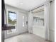 Bright entryway with white tile floors, wainscoting detail, and natural light from the decorative glass front door at 3616 Stardust Pl, Sarasota, FL 34232