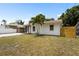 Charming single-story home boasts a well-maintained yard with a young palm tree and a partially fenced perimeter at 3616 Stardust Pl, Sarasota, FL 34232