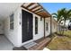 Elegant front entrance featuring a decorative door, stylish lighting, and charming wooden porch at 3616 Stardust Pl, Sarasota, FL 34232