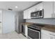 Bright kitchen with stainless steel appliances, granite countertops, and white cabinetry at 3616 Stardust Pl, Sarasota, FL 34232