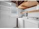 This laundry room includes a washer, a dryer, and shelving with exposed ceiling at 3616 Stardust Pl, Sarasota, FL 34232