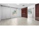 Bright living room with white plank walls, wood-look tile floors, and stylish wood slat accent wall at 3616 Stardust Pl, Sarasota, FL 34232