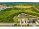 An aerial view showcasing multiple homes with backyard pools next to a pond and lush greenery at 370 Londonderry Dr, Sarasota, FL 34240