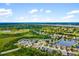Expansive aerial view showcasing a neighborhood nestled among ponds, golf courses and lush greenery at 370 Londonderry Dr, Sarasota, FL 34240