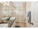 Bathroom featuring double sinks, a granite countertop, a large mirror, and a glass-enclosed shower at 370 Londonderry Dr, Sarasota, FL 34240