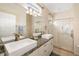 Bathroom featuring double sinks, a granite countertop, a large mirror, and a glass-enclosed shower at 370 Londonderry Dr, Sarasota, FL 34240