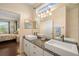 Bright bathroom featuring dual sinks, granite countertops, and a view into an adjacent bedroom at 370 Londonderry Dr, Sarasota, FL 34240