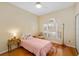 A cozy bedroom featuring wood floors, a ceiling fan, and a bright window with plantation shutters at 370 Londonderry Dr, Sarasota, FL 34240
