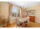 Dining room with hardwood floors, neutral walls, a chandelier, and a large window with backyard view at 370 Londonderry Dr, Sarasota, FL 34240