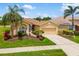 Well-maintained single-story home with an attached two-car garage, mature landscaping, and a neatly manicured lawn at 370 Londonderry Dr, Sarasota, FL 34240