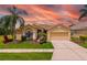 Charming single-story home with a two-car garage, beautiful landscaping, and a vibrant, colorful sunset backdrop at 370 Londonderry Dr, Sarasota, FL 34240