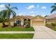 Inviting single-story home featuring lush landscaping, a two-car garage, and an arched entryway at 370 Londonderry Dr, Sarasota, FL 34240