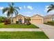 Attractive single-story home with a two-car garage, lush greenery, and a well-kept lawn and landscaping at 370 Londonderry Dr, Sarasota, FL 34240