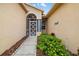 Close up of a front entrance featuring a screened doorway, complemented by lush, colorful landscaping at 370 Londonderry Dr, Sarasota, FL 34240