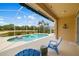 Screened-in pool and patio with a view of the backyard pond and tropical landscaping at 370 Londonderry Dr, Sarasota, FL 34240