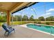 Screened-in pool area with outdoor seating and views of the surrounding green space at 370 Londonderry Dr, Sarasota, FL 34240